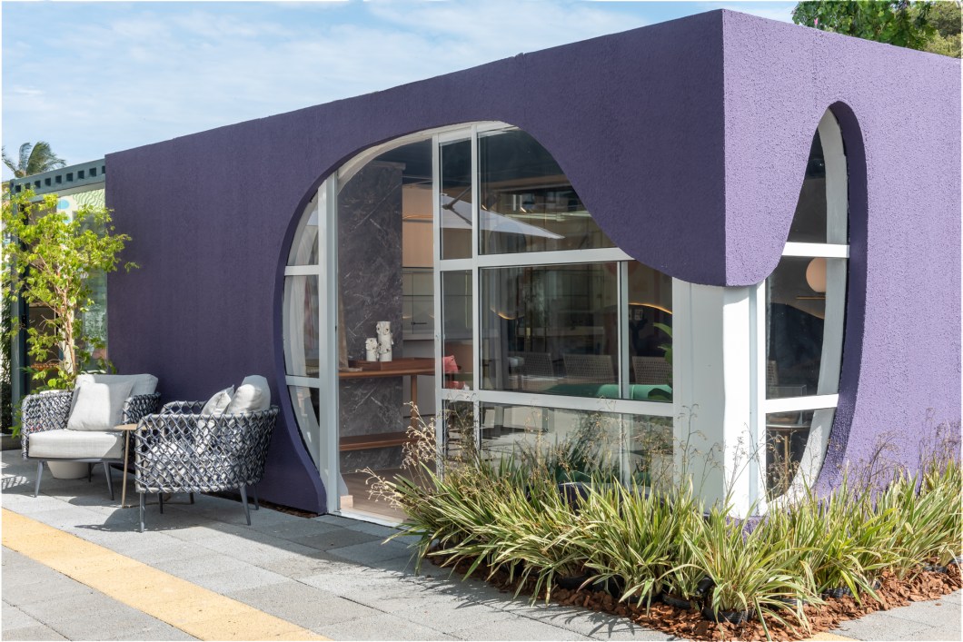 Iago Martins e Lais Almeida - Joalheria. Situada às margens da praia de Piratininga, a joalheira é um projeto de interiores localizado na parte exterior da mostra, onde o visitante é recepcionado e interage com as formas orgânicas trabalhadas na fachada rodeada de um paisagismo exuberante. Um espaço proposto para homenagear os clientes da Joalheria Ricardo Vieira, ao longo dos seus 21 anos de parceria com a CASACOR. No interior, há várias peças expostas em estruturas anexas às paredes em formas inspiradas no Art Deco. O piso de madeira e as cores marcantes como o roxo, o dourado e o verde dão o tom de sofisticação, sem se desvincular da despojada atmosfera praiana do local. Iago Martins e Lais Almeida - Joalheria. Situada às margens da praia de Piratininga, a joalheira é um projeto de interiores localizado na parte exterior da mostra, onde o visitante é recepcionado e interage com as formas orgânicas trabalhadas na fachada rodeada de um paisagismo exuberante. Um espaço proposto para homenagear os clientes da Joalheria Ricardo Vieira, ao longo dos seus 21 anos de parceria com a CASACOR. No interior, há várias peças expostas em estruturas anexas às paredes em formas inspiradas no Art Deco. O piso de madeira e as cores marcantes como o roxo, o dourado e o verde dão o tom de sofisticação, sem se desvincular da despojada atmosfera praiana do local.