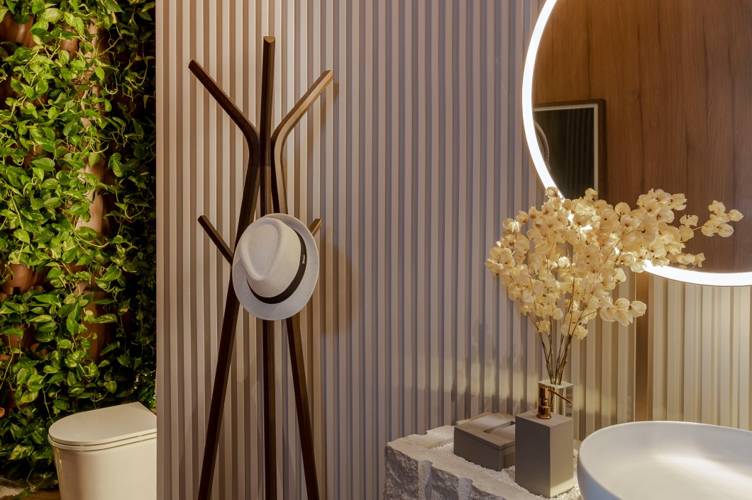 Gabi Martins - Lavabo in. O étnico se funde ao natural em menos de 8 m² no lavabo onde o aconchego é palavra de ordem. Uma cápsula de madeira abraça o ambiente e divide espaço com uma parede viva, trazendo a natureza para o lar. Pedras naturais, como o granito bruto, trabalhadas de forma ousada e inusitada foram utilizadas atestando uma ambientação sem excessos e atemporal. Tons sofisticados em acessórios conferem galhardia, enquanto peças de arte assinadas elevam o requinte oferecendo uma experiência sensorial aos visitantes desse charmoso espaço. Gabi Martins - Lavabo in. O étnico se funde ao natural em menos de 8 m² no lavabo onde o aconchego é palavra de ordem. Uma cápsula de madeira abraça o ambiente e divide espaço com uma parede viva, trazendo a natureza para o lar. Pedras naturais, como o granito bruto, trabalhadas de forma ousada e inusitada foram utilizadas atestando uma ambientação sem excessos e atemporal. Tons sofisticados em acessórios conferem galhardia, enquanto peças de arte assinadas elevam o requinte oferecendo uma experiência sensorial aos visitantes desse charmoso espaço.