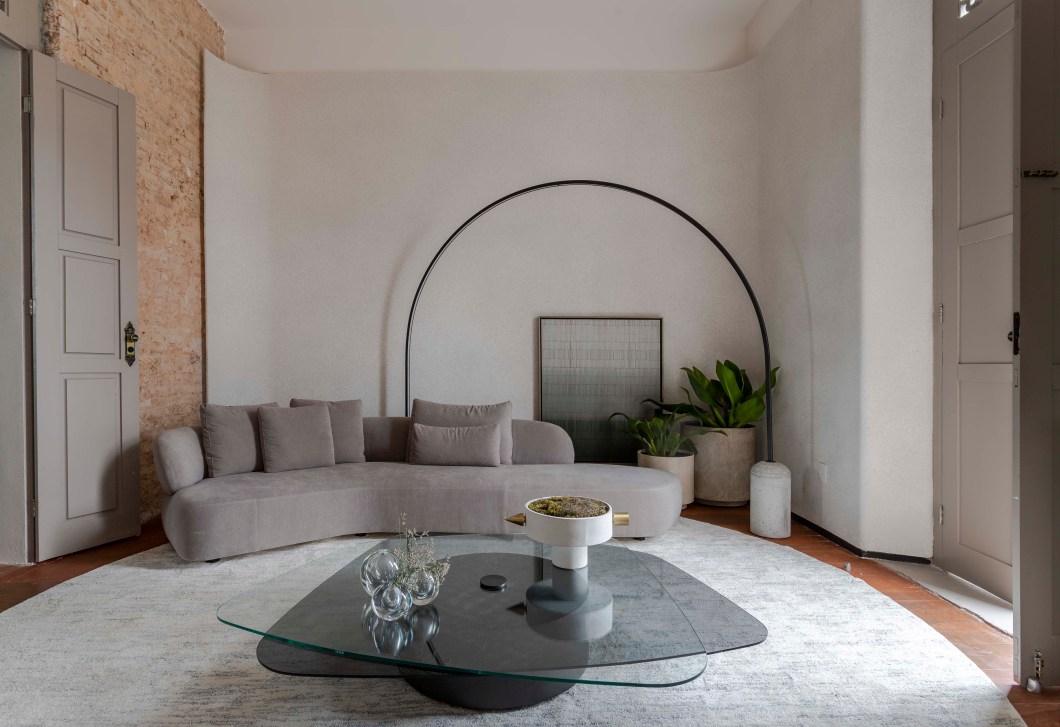 Hertha Dantas - Living refletIR. Com 45 m², o living com sacada escultural da icônica casa “castelinho” do início do século XX preserva a estrutura e materiais existentes, trazendo soluções espaciais e de design no reflexo dos diferentes “eus” no infinito particular. Espalham-se através do layout, multiplicam-se através das repetições das formas e dos objetos e se amarram através das camadas do novo sobre o antigo. Ao adentrar, um atemparo curvo com toque de luz da luminária ferrão aguça a descoberta do living, que se revela conceitual, moderno e minimalista, através do layout open space. O aparador/bar de design autoral “nasce” como elo dessa integração entre os usos, jantar e estar. Já a mesa redonda Cisa do designer Ronald Sasson e o tapete em tramas de fio belga da Via Star Collection UP Designer refletem a integração das formas. Por fim, as paredes recebem uma nova camada, com destaque para conservação da icônica parede de tijolinho aparente. Hertha Dantas - Living refletIR. Com 45 m², o living com sacada escultural da icônica casa “castelinho” do início do século XX preserva a estrutura e materiais existentes, trazendo soluções espaciais e de design no reflexo dos diferentes “eus” no infinito particular. Espalham-se através do layout, multiplicam-se através das repetições das formas e dos objetos e se amarram através das camadas do novo sobre o antigo. Ao adentrar, um atemparo curvo com toque de luz da luminária ferrão aguça a descoberta do living, que se revela conceitual, moderno e minimalista, através do layout open space. O aparador/bar de design autoral “nasce” como elo dessa integração entre os usos, jantar e estar. Já a mesa redonda Cisa do designer Ronald Sasson e o tapete em tramas de fio belga da Via Star Collection UP Designer refletem a integração das formas. Por fim, as paredes recebem uma nova camada, com destaque para conservação da icônica parede de tijolinho aparente.