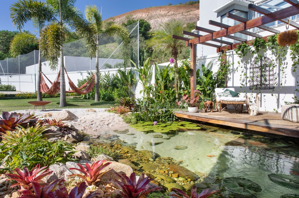 Projeto de paisagismo assinado por ANA VERAS com lago projetado por BERNARDO VIEIRA foto 5 Jardim de 900 m² tem lago com peixes, praia de areia branca e pomar. Projeto de Ana Veras e Bernardo Vieira. Na foto, jardim com lago, pergolado, prainha de areia e rede.