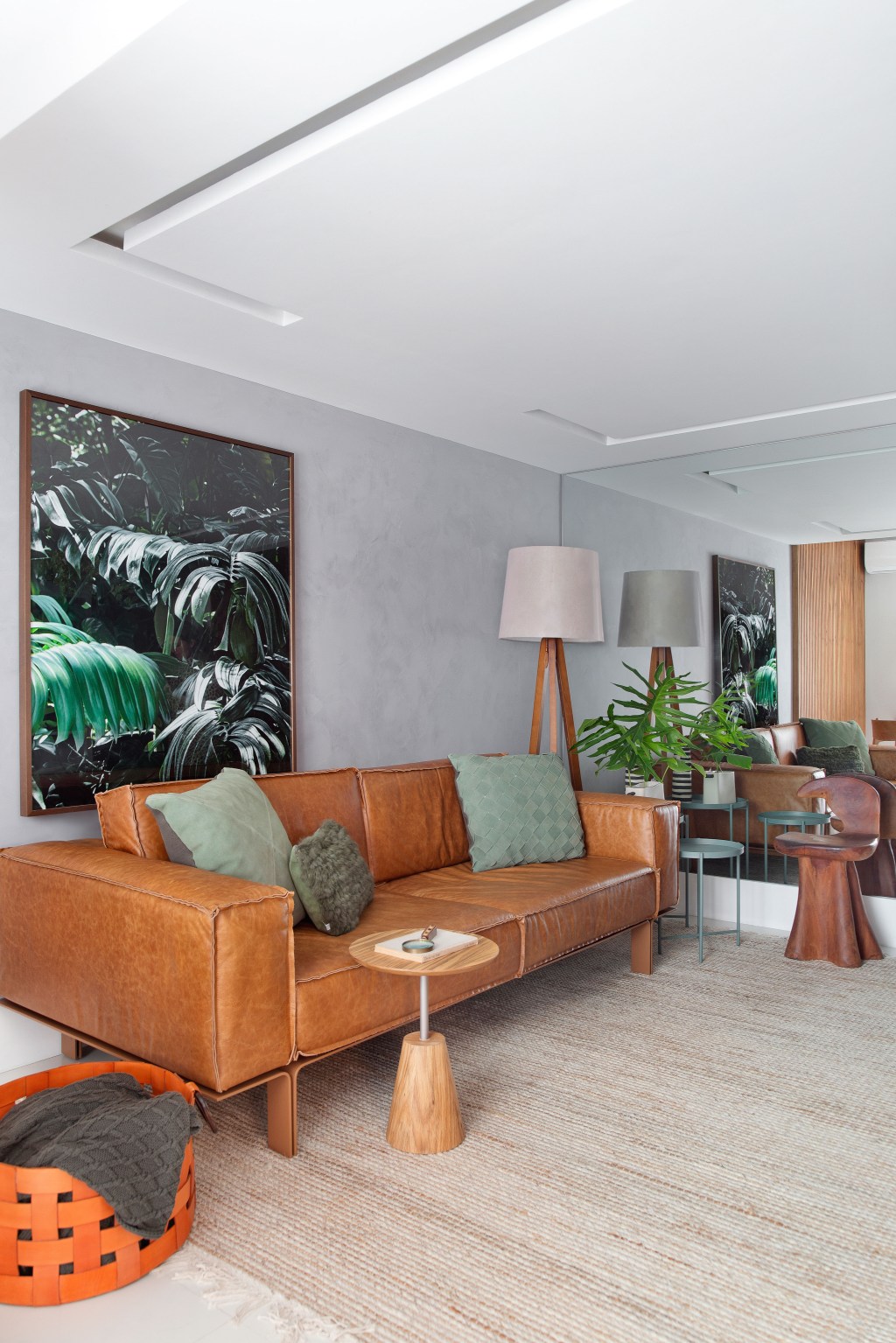 Sem quebra-quebra, apê de 130 m² no Rio ganha décor cozy e minimalista. Projeto Travessa Arquitetura. Na foto, sala com sofá de couro, quadro e tapete.