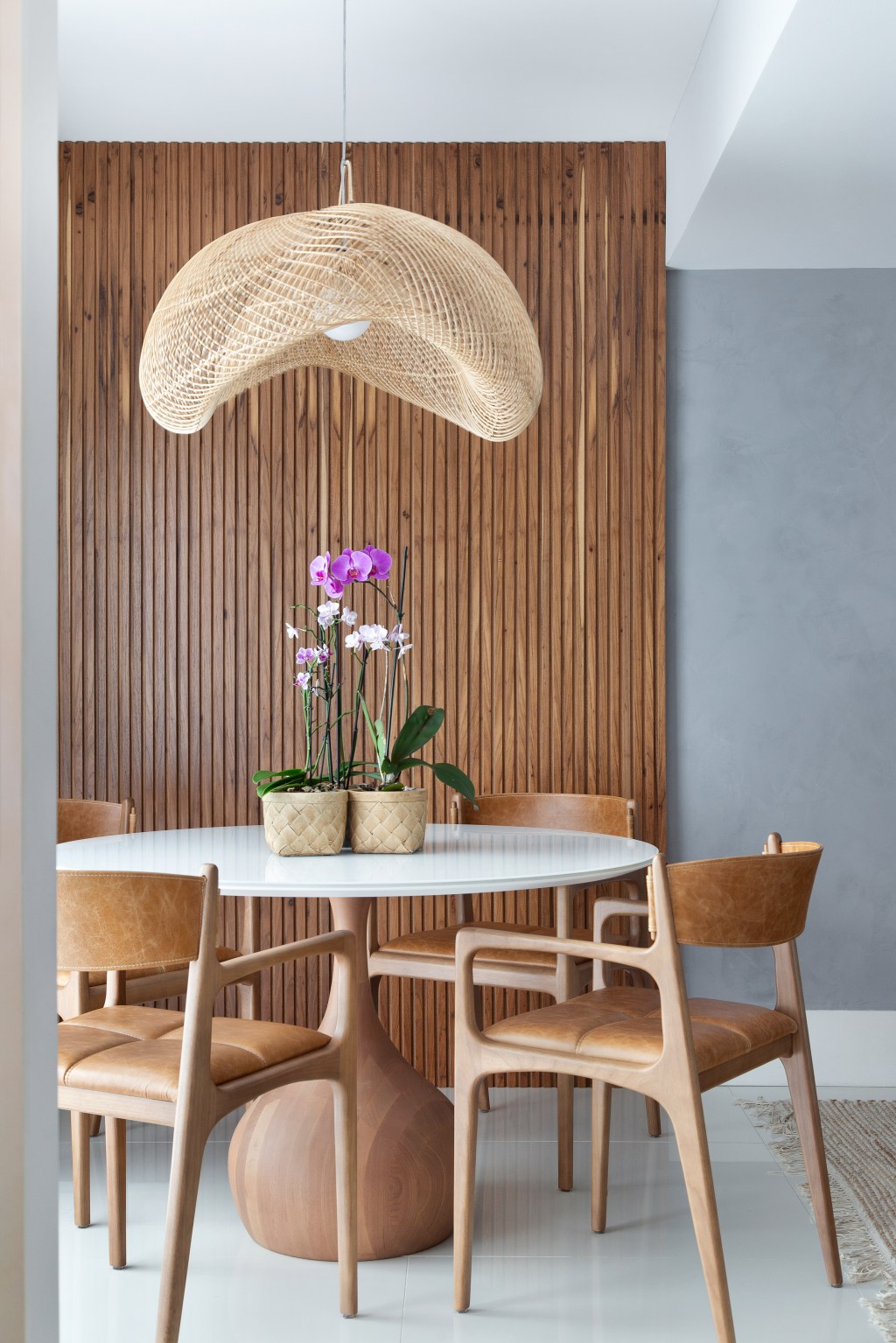 sem-quebra-quebra-ape-130-m2-rio-decor-cozy-minimalista-travessa-arquitetura-credito-raiana-medina (9) Sem quebra-quebra, apê de 130 m² no Rio ganha décor cozy e minimalista. Projeto Travessa Arquitetura. Na foto, sala de jantar com mesa redonda e parede ripada.
